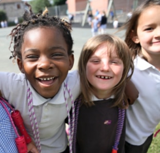 Dvě mladé dívky ve stejnokrojích napodobují čištění zubů kartáčky z lepenky